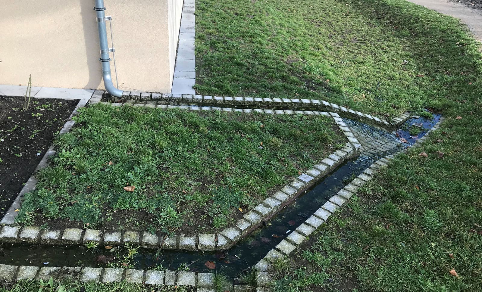 Einleitung von Regenwasser in eine Versickerungsmulde - als Teil der Grundstücksentwässerung