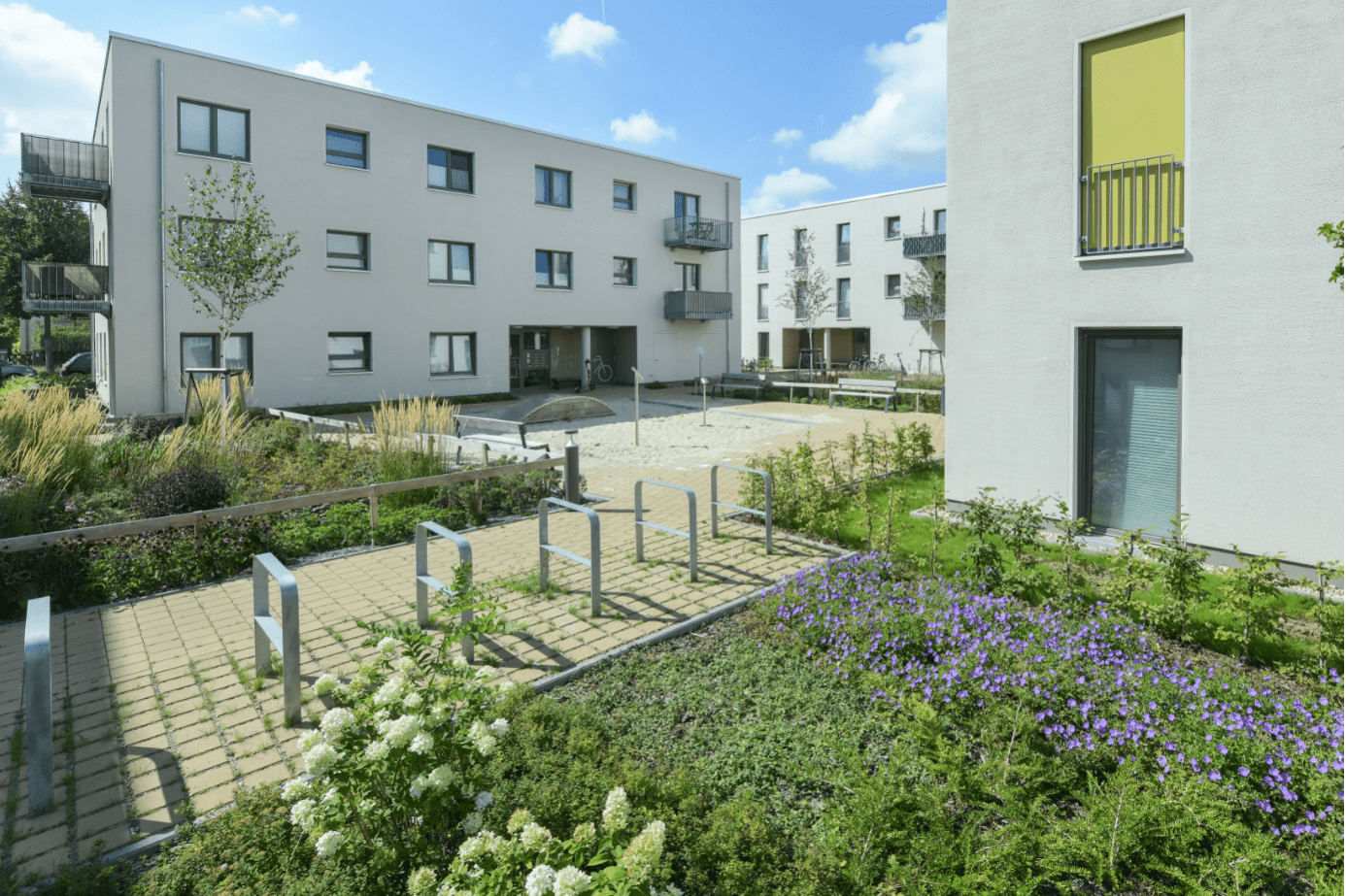 Quartiers-Innenhof mit wasserdurchlässigen Wegbelägen und Grünflächen