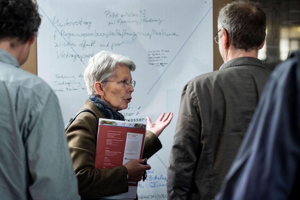 Eine Person spricht vor einer beschriebenen Stellwand