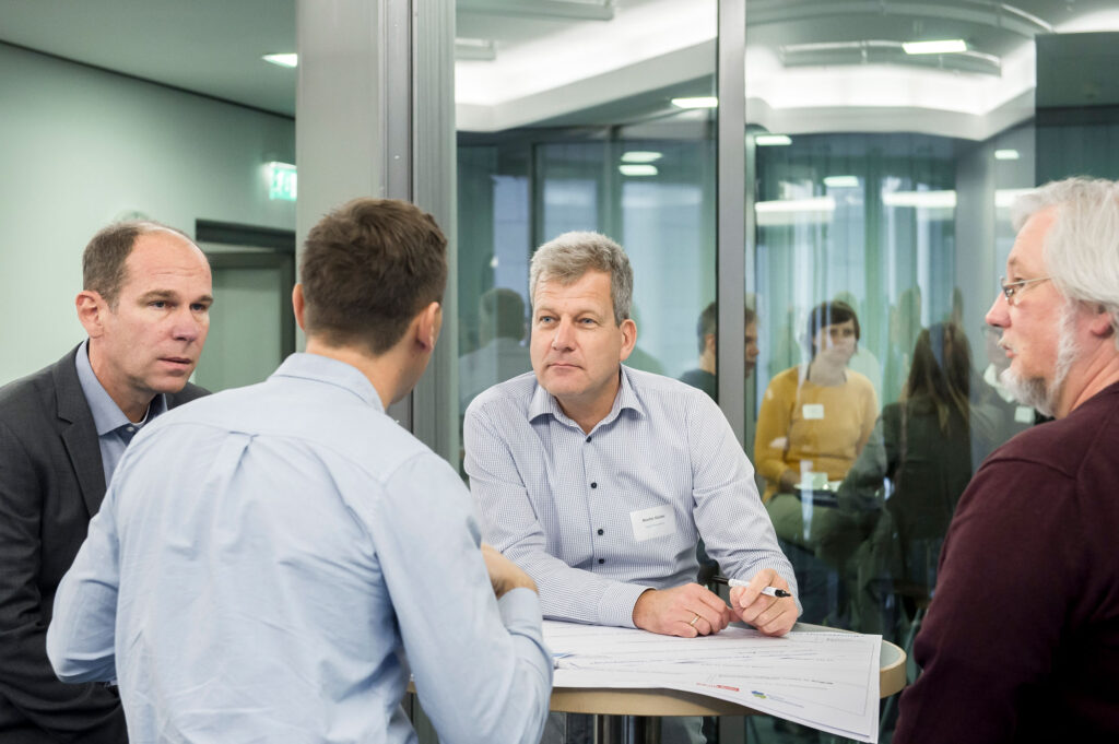 Teilnehmende einer Arbeitsgruppe an einem Tisch im Gespräch