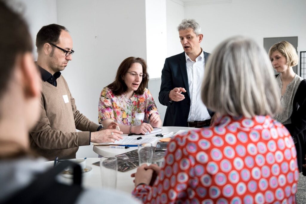 mehrere Personen an einem Tisch im Gespräch