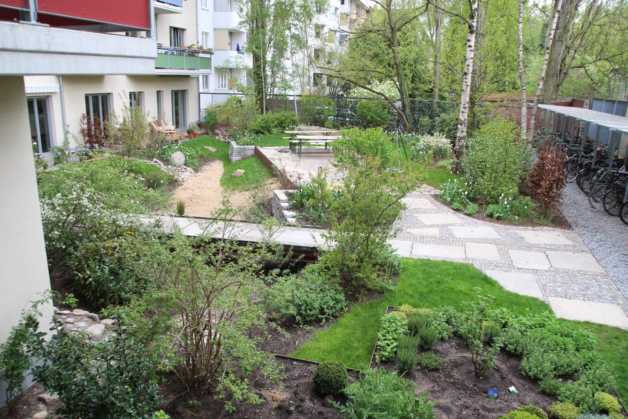 Hinterhof-Garten der Baugruppe-Moabit-B27 mit Mulden und teildurchlässigen Terrassensteinen