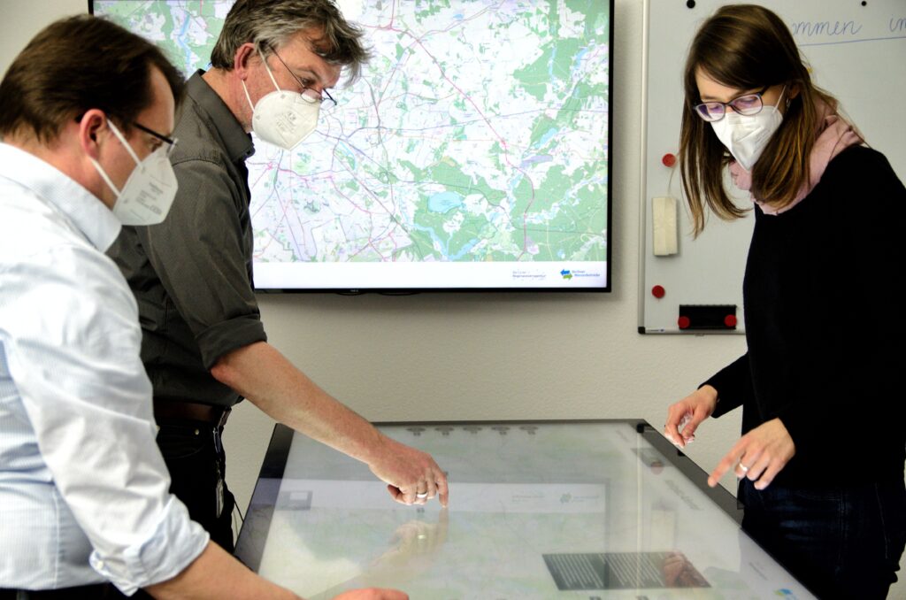 3 Personen arbeiten am digitalen Planungstisch