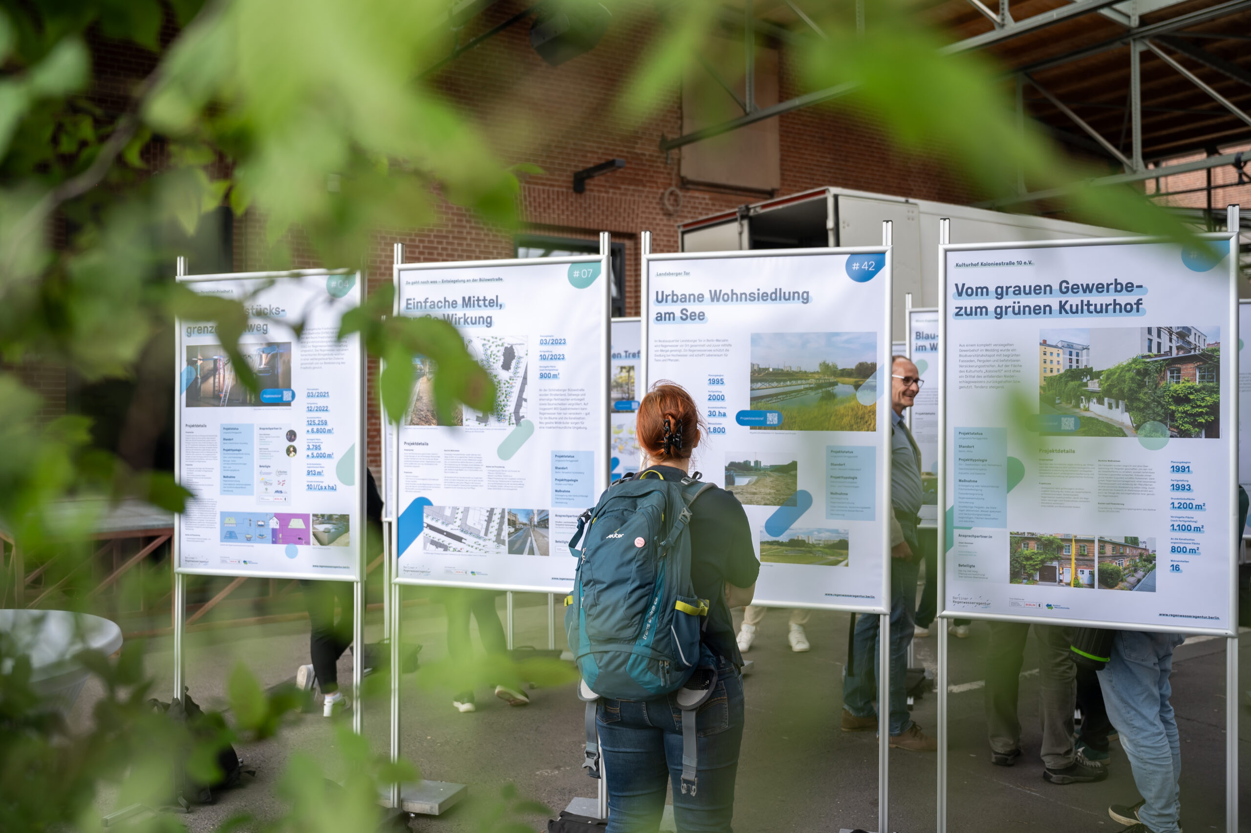 Person sieht sich ein Plakat der Ausstellung an