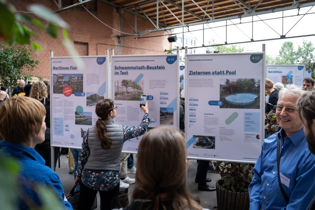 Teilnehmende des Forums inmitten der Plakatausstellung