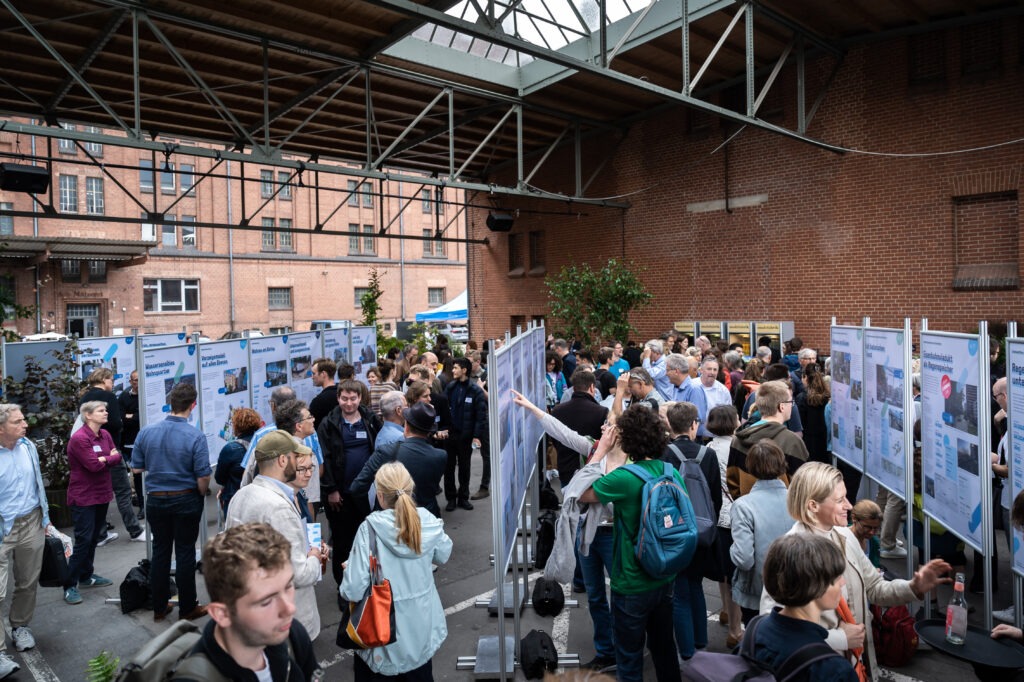 Teilnehmende des Forums schauen sich die Plakatausstellung an.