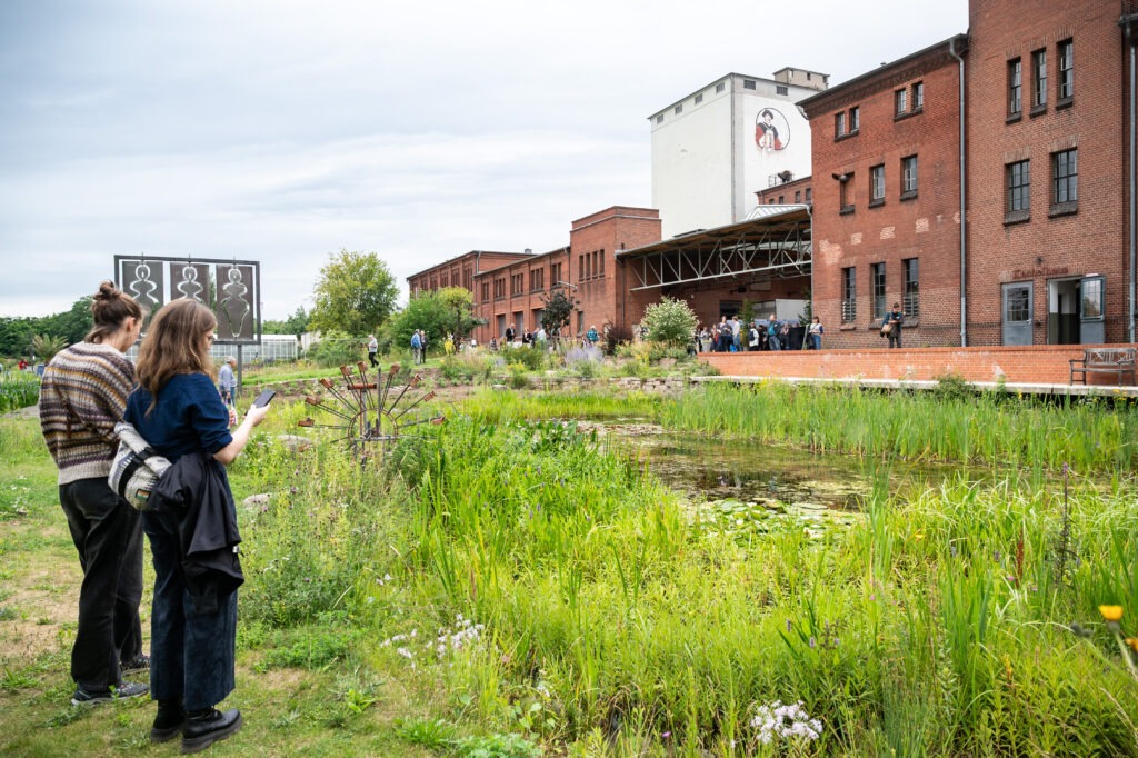 Zwei Personen am Wasser auf dem Gelände der Malzfabrik