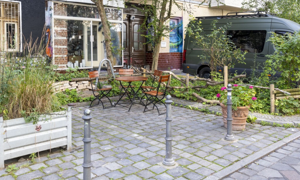 Sitzgelegenheiten zwischen Grünflächen und Beeten