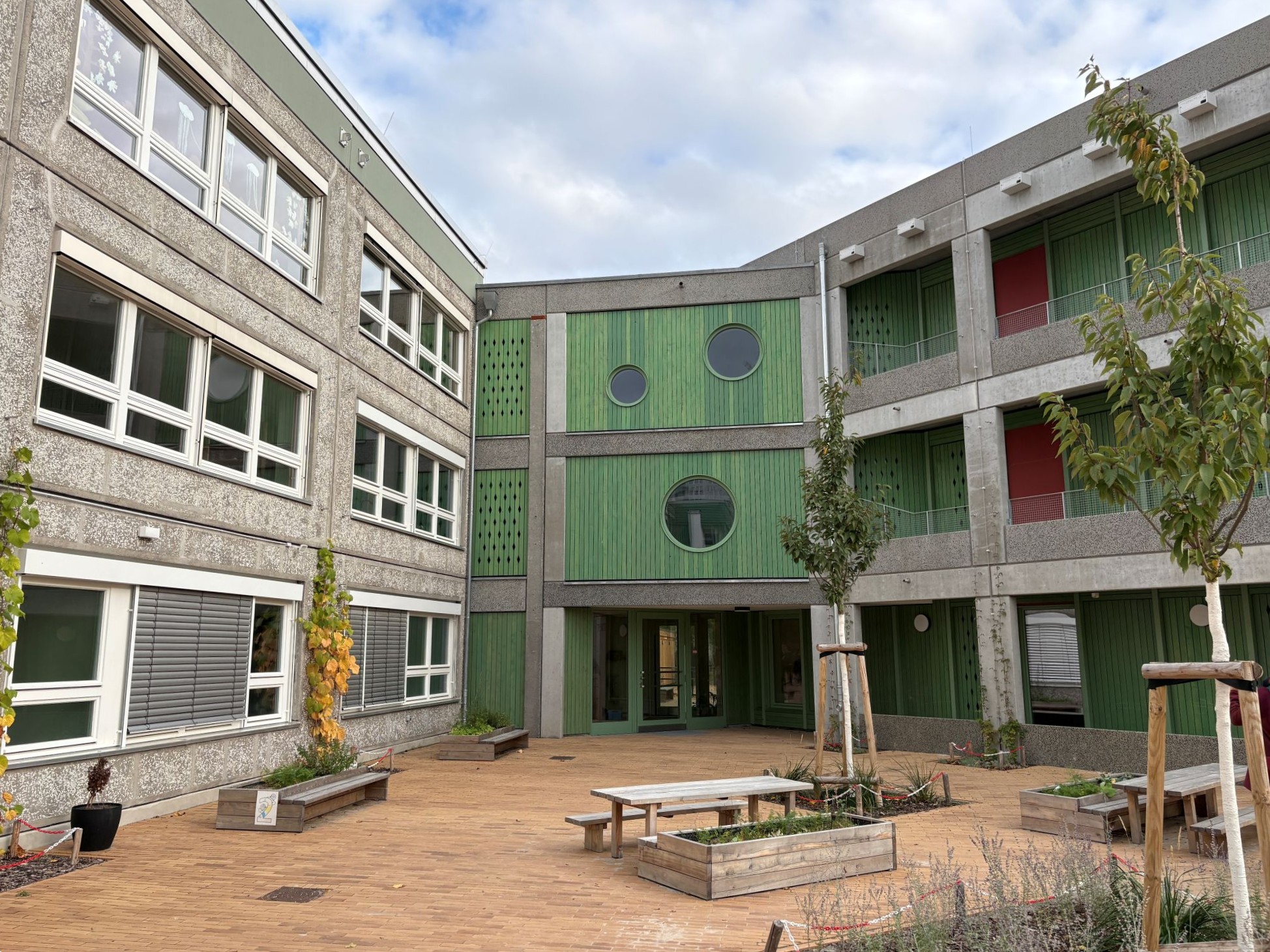 Gebäude der Kita Bewegungsreich mit Teilansicht auf die Außenanlage