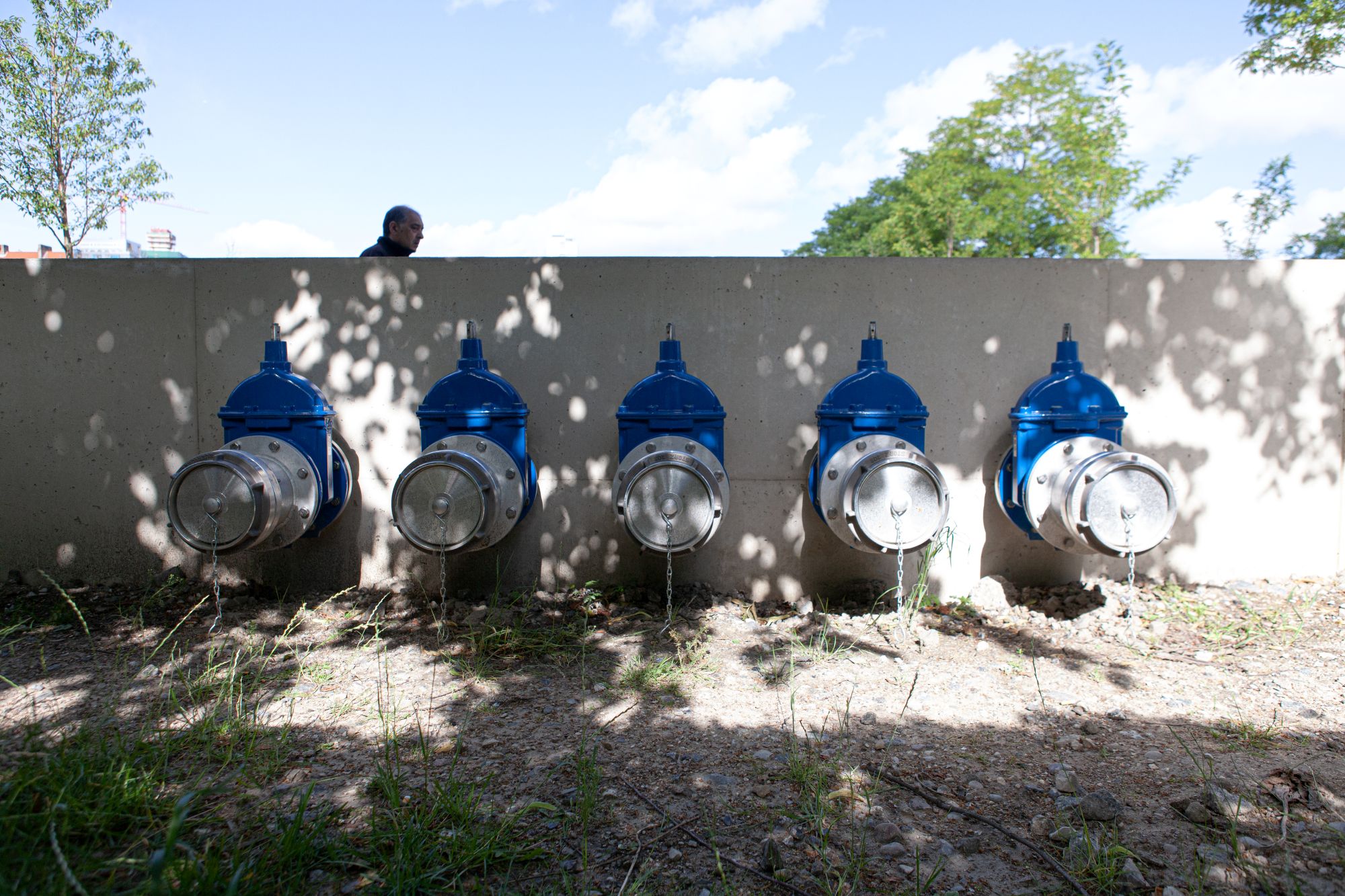Entleerungsarmaturen an der Außenseite der den Park einrahmenden Betonmauer: Tankfahrzeuge können hierüber Wasser aus dem Regenwassersammelbecken im Park abpumpen. Genutzt wird dieses zum Gießen von Grünflächen im gesamten Stadtgebiet.