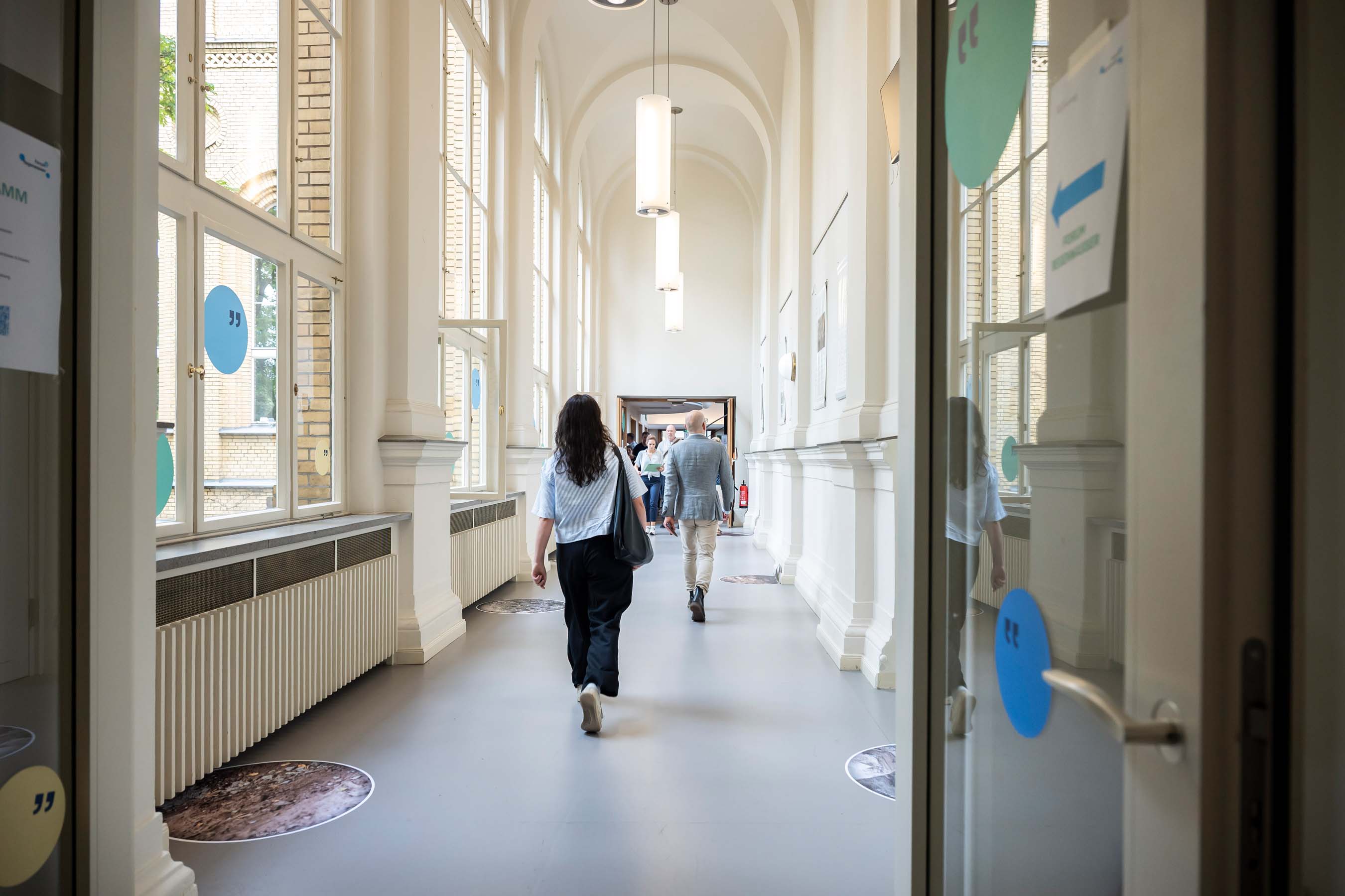 Forum Regenwasser 2026 - Eingangsbereich mit Bodenaufklebern, welche unterschiedliche Einblicke geben, was sich in urbanen Böden verbirgt.